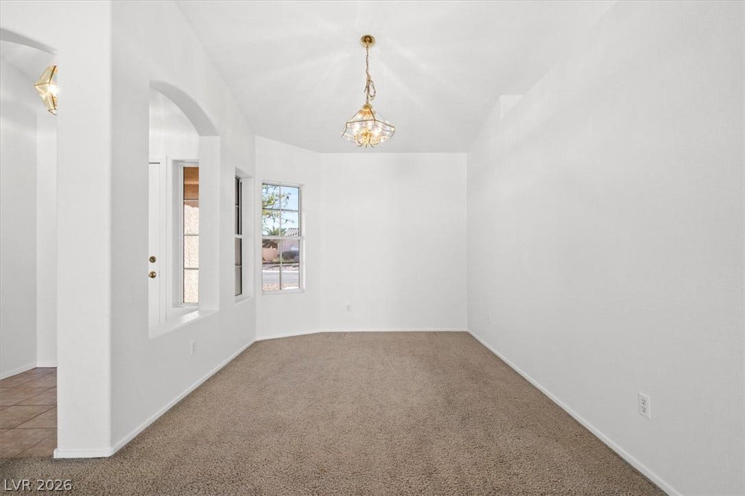 3535 Barrel Bronco Court, North Las Vegas, NV 89032 An elegant chandelier illuminates this versatile space featuring neutral carpeting and arched wall cutouts.