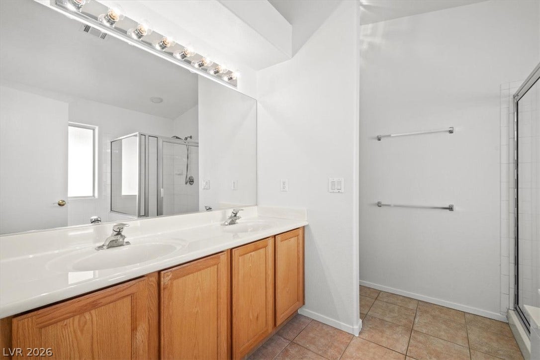 3535 Barrel Bronco Court, North Las Vegas, NV 89032 Tile flooring and a long double vanity define this well-appointed bathroom space.