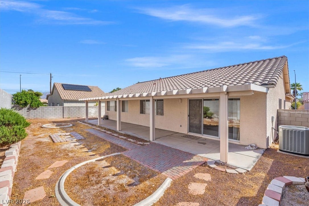 3535 Barrel Bronco Court, North Las Vegas, NV 89032 A spacious covered patio spans the back of this stucco home with a tiled roof.