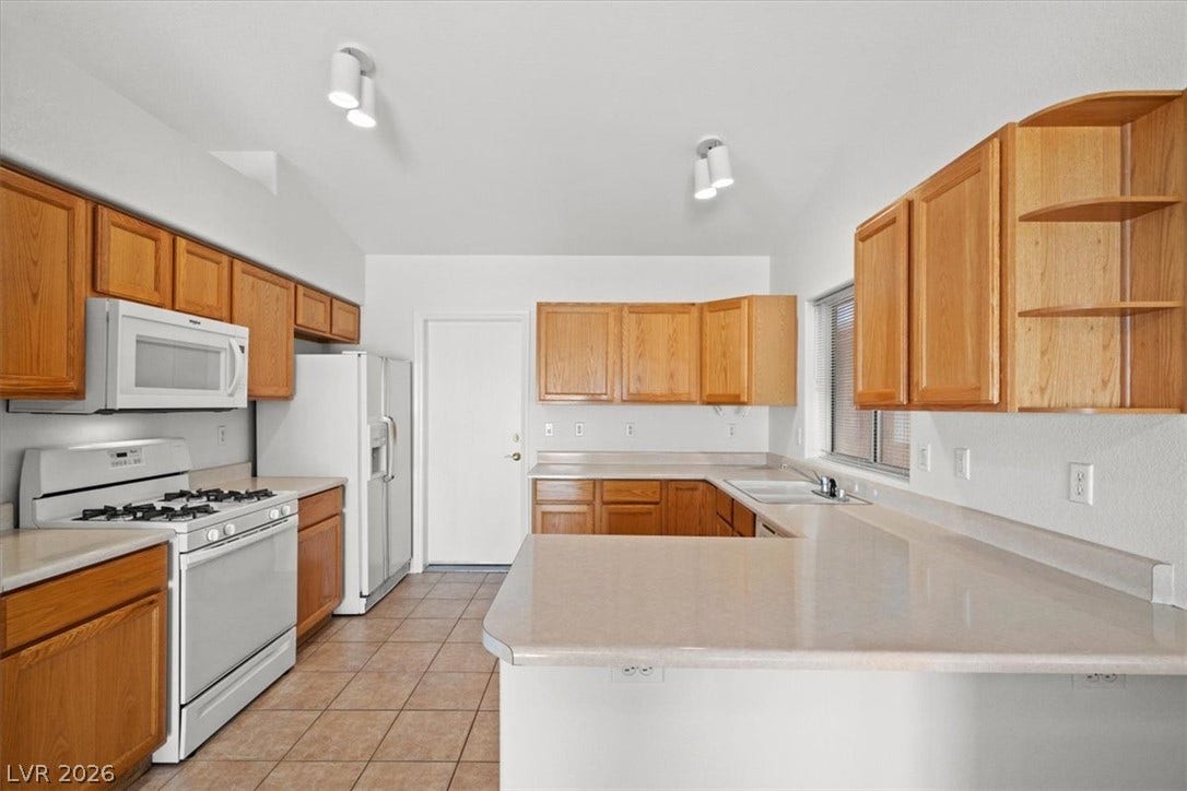 3535 Barrel Bronco Court, North Las Vegas, NV 89032 A classic kitchen with generous counter space, enduring wood cabinetry, and neutral tile flooring.