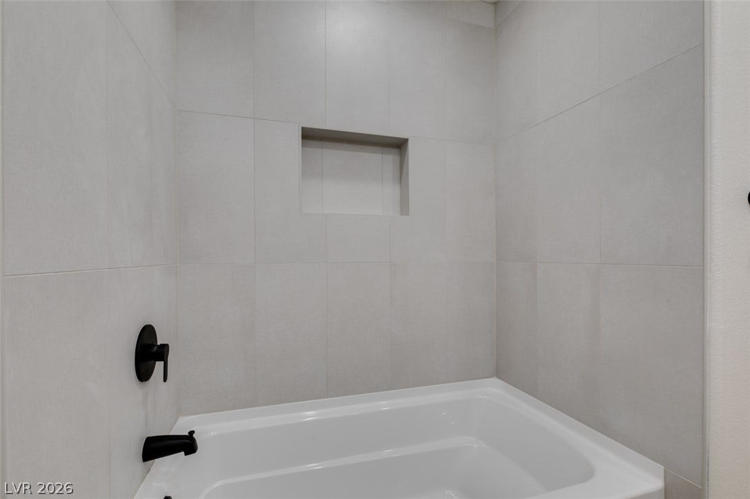 197 Sicily Hills Court, Henderson, NV 89012 Floor-to-ceiling tiles and clean-lined hardware define this deep soaking tub alcove.