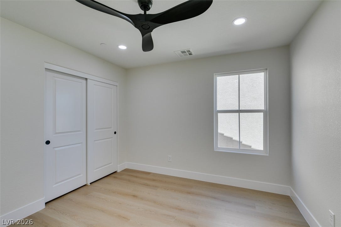 197 Sicily Hills Court, Henderson, NV 89012 Smooth wood-look flooring and recessed lighting define this inviting bedroom space.