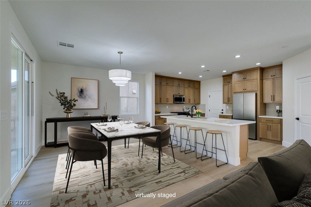 197 Sicily Hills Court, Henderson, NV 89012 An open floorplan seamlessly connects the dining area to a modern kitchen with wood floors.