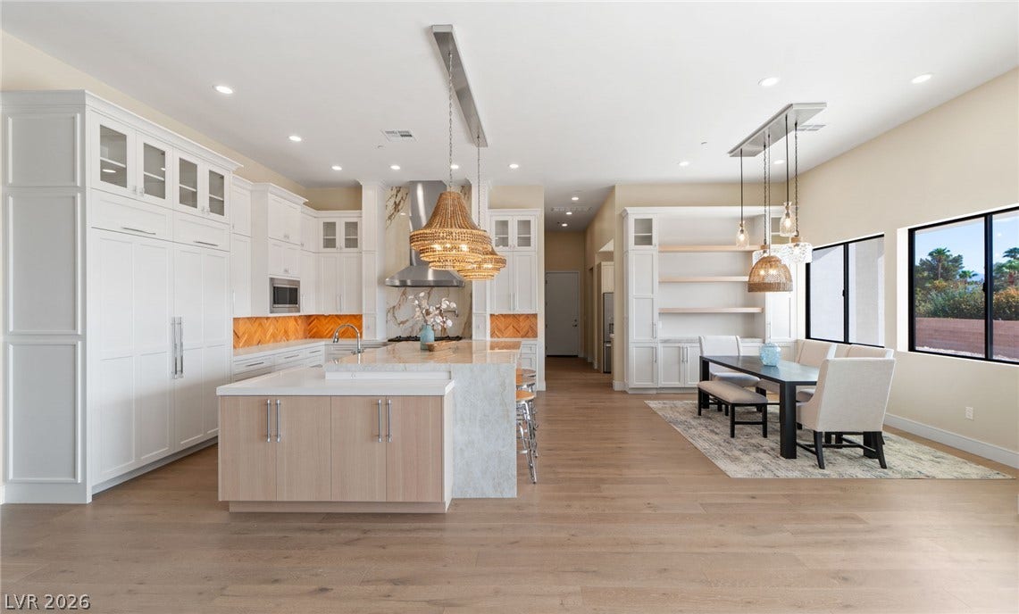 Gleaming hardwood floors and a spacious island anchor this light-filled gourmet culinary space.