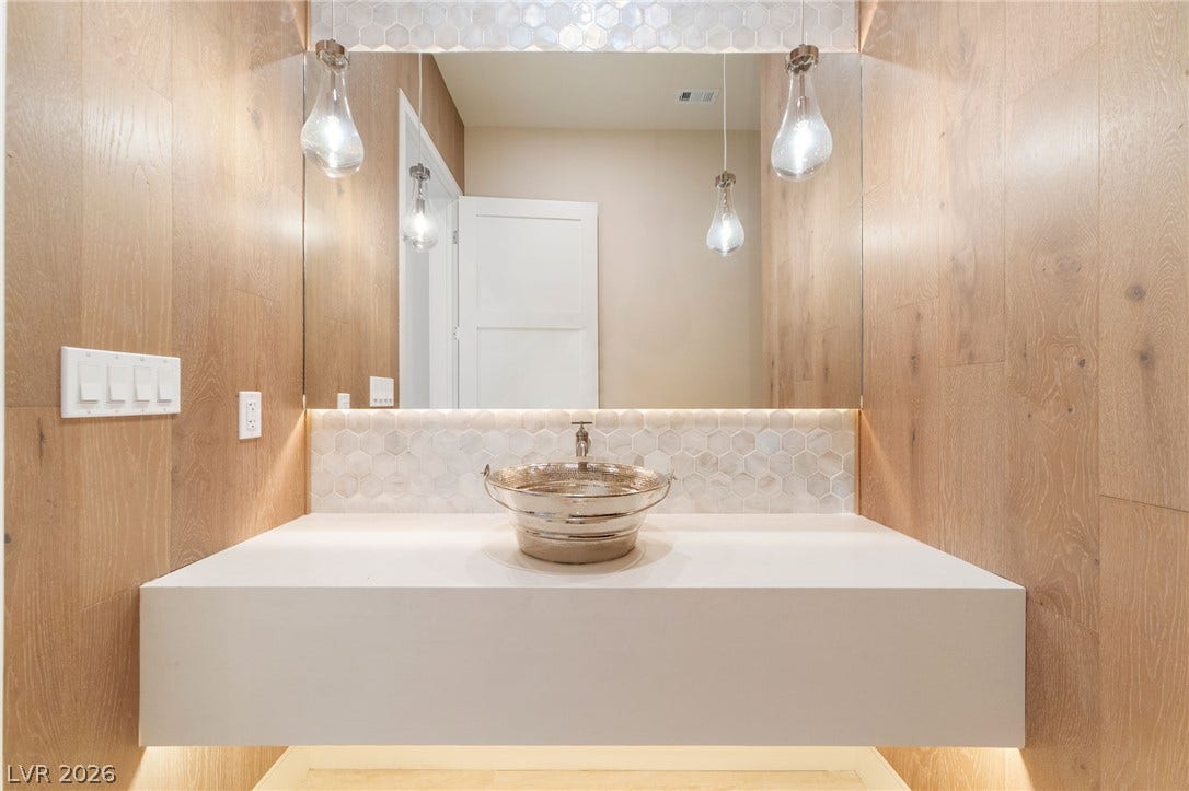 Warm wood wall paneling and a floating vanity define this modern powder room.