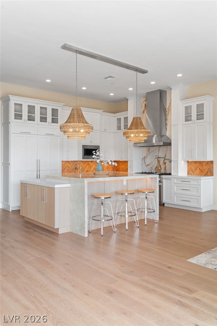 Crisp white cabinetry and a waterfall-edge island anchor this modern open culinary space.