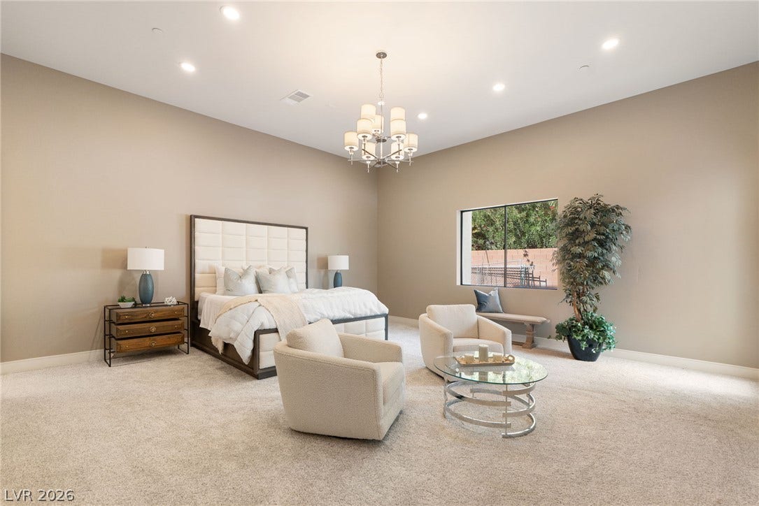 High ceilings and soft carpet floor define this relaxing primary bedroom suite.