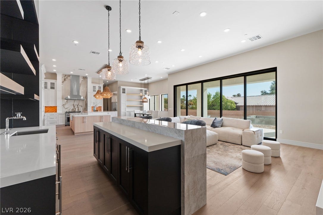 An open floor plan connects the sleek kitchen to the living area through sliding doors.