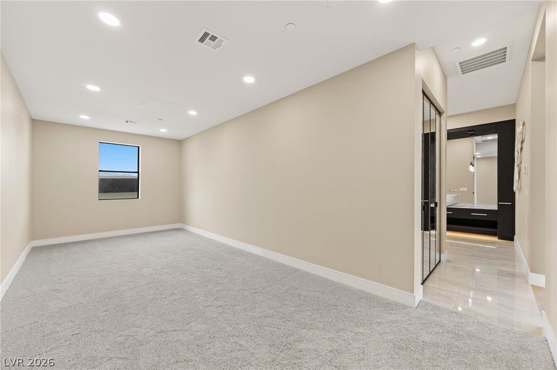 Plush carpeting and modern recessed lighting create a comfortable atmosphere in this versatile space.