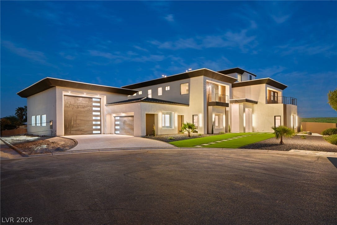 Striking contemporary architecture defines this luxury multi-level estate with dramatic exterior lighting.