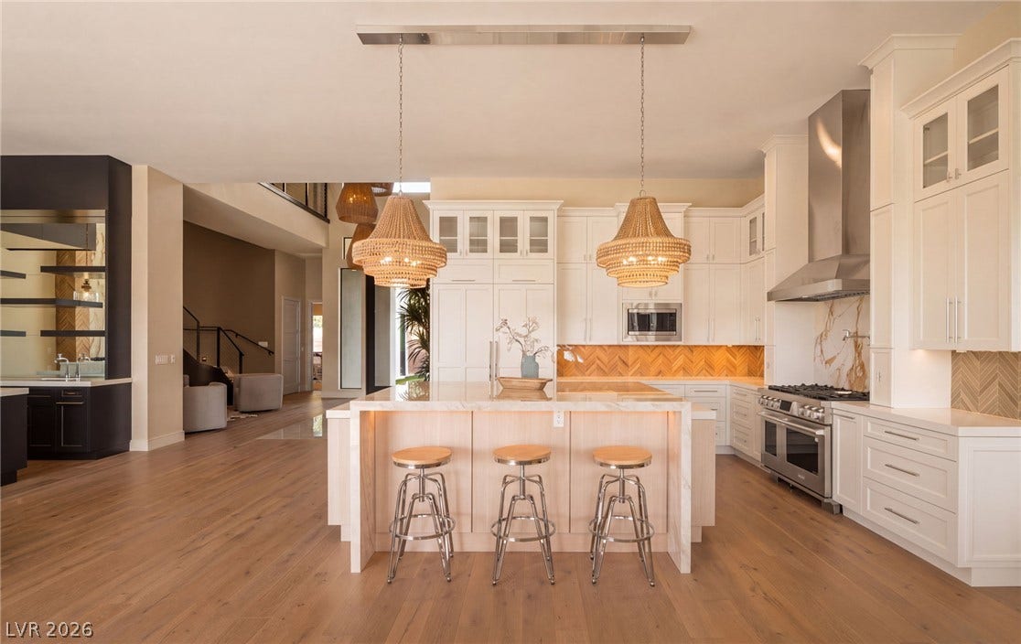 Gleaming hardwood floors and a spacious island anchor this light-filled modern kitchen.
