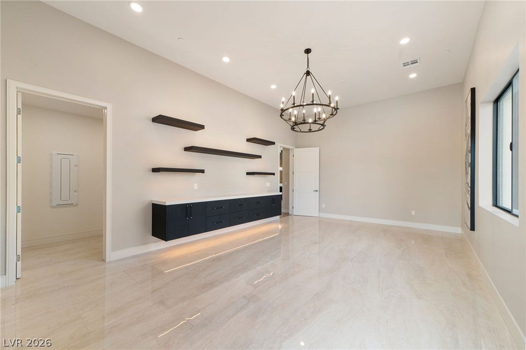 Polished tile flooring and minimalist built-in shelving define this versatile modern space.