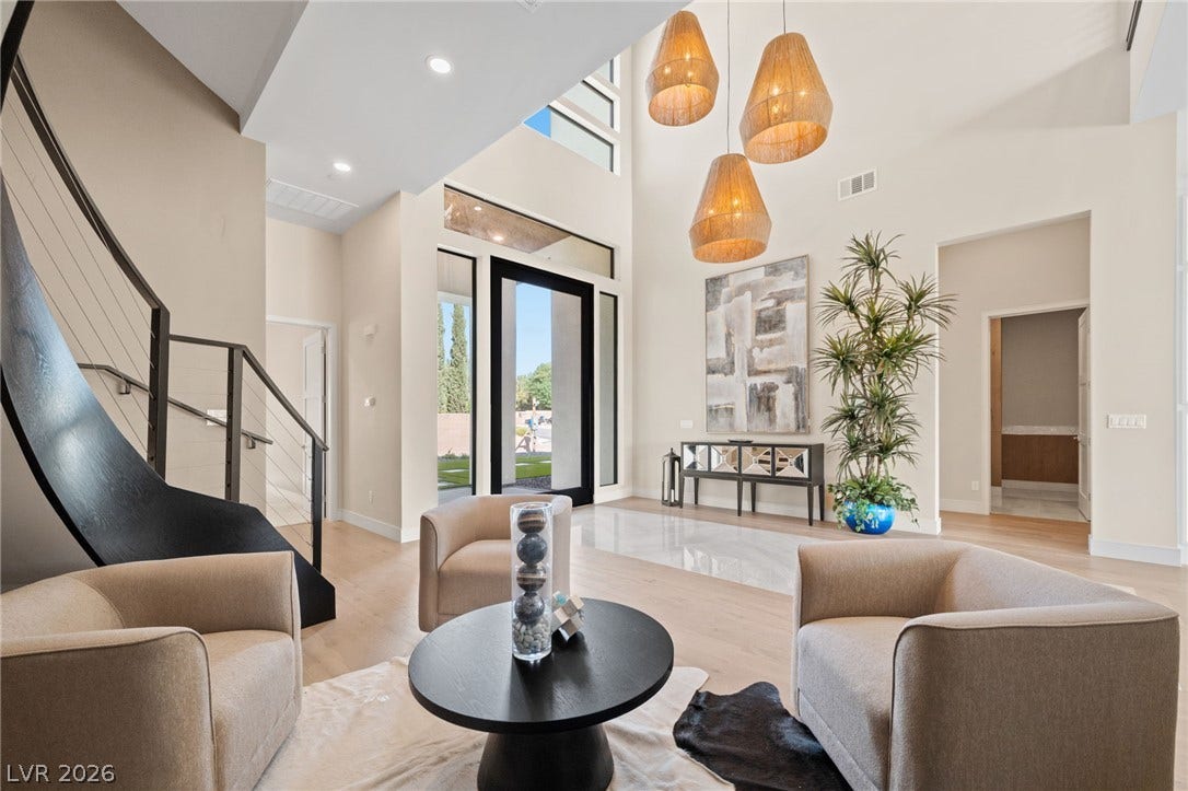 Soaring ceilings and a dramatic curved staircase define this light-filled entry foyer.