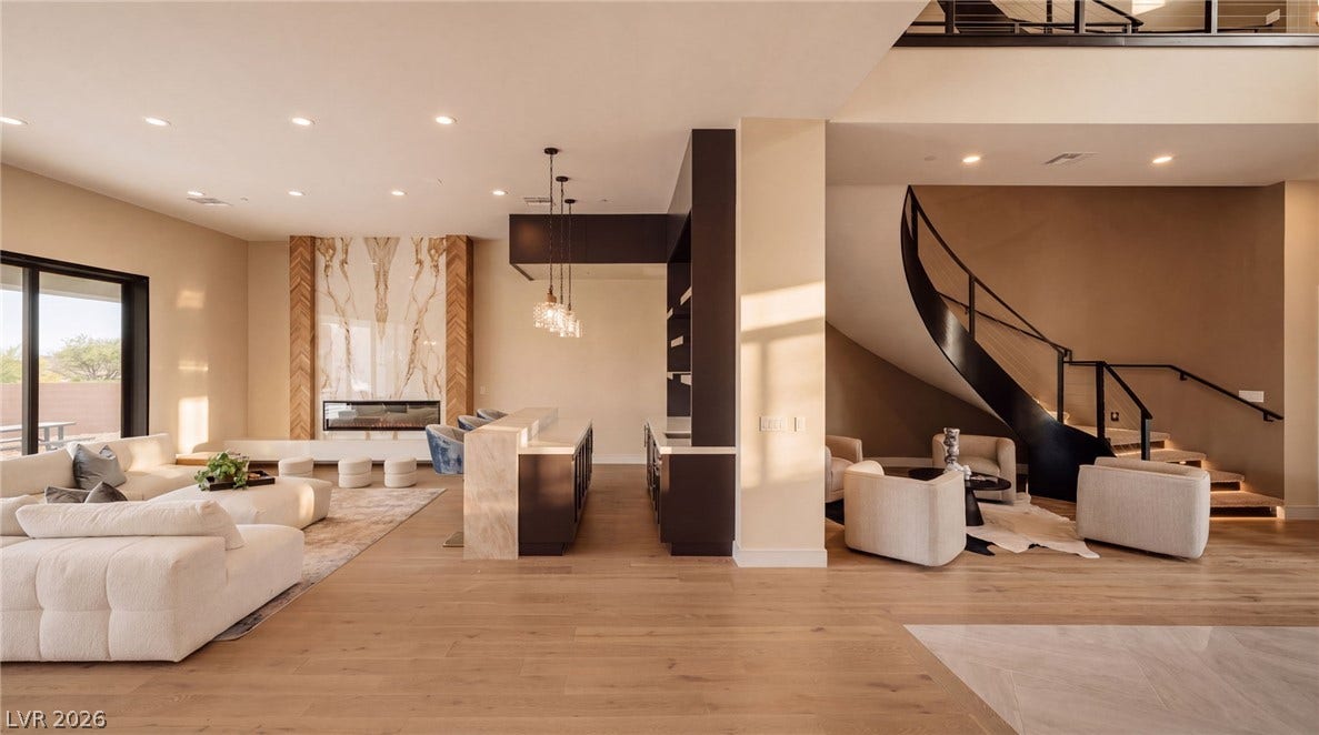 An open floorplan seamlessly connects the living spaces with a striking curved staircase.
