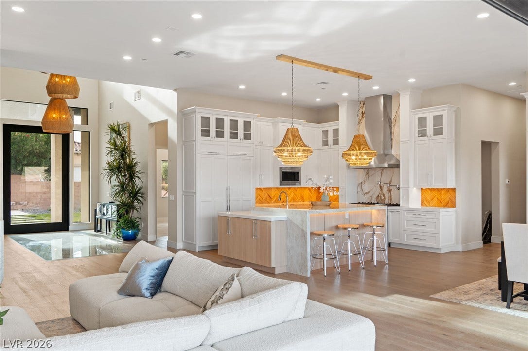 An open floorplan seamlessly connects the airy living space to a modern kitchen.