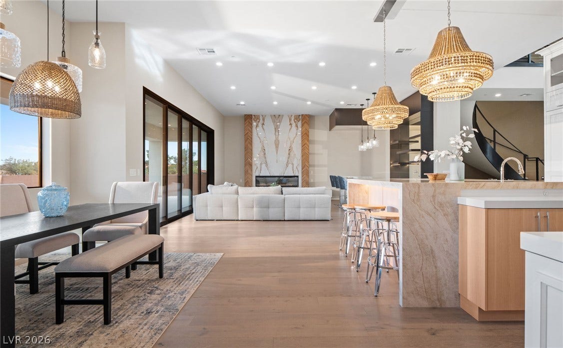 Gleaming hardwood floors and a towering stone fireplace define this light-filled open concept space.