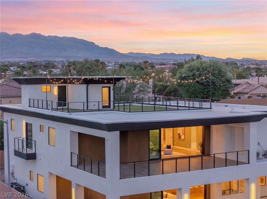 Dramatic mountain backdrops frame this contemporary multi-level home featuring an expansive rooftop terrace.