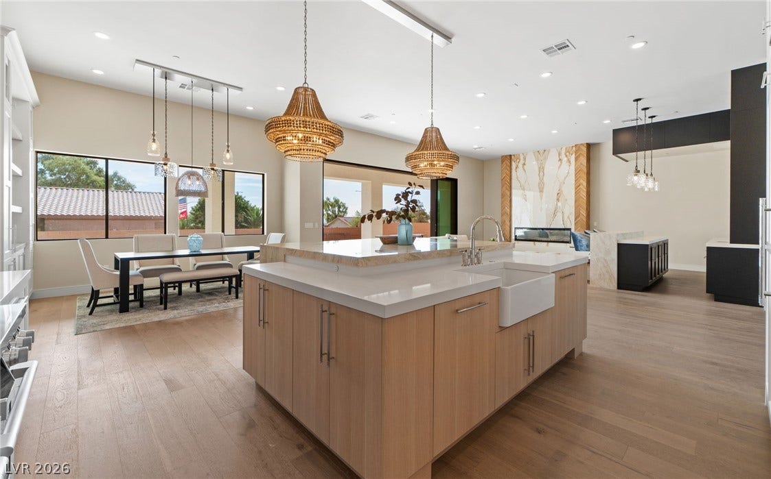 Gleaming hardwood floors and a spacious island anchor this expansive, open-concept kitchen space.