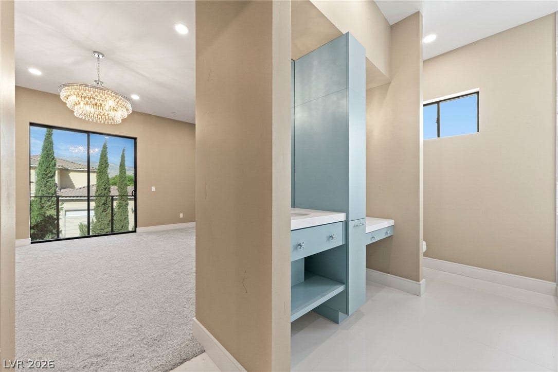 Gleaming tile floors and high ceilings define this modern bathroom vanity area.
