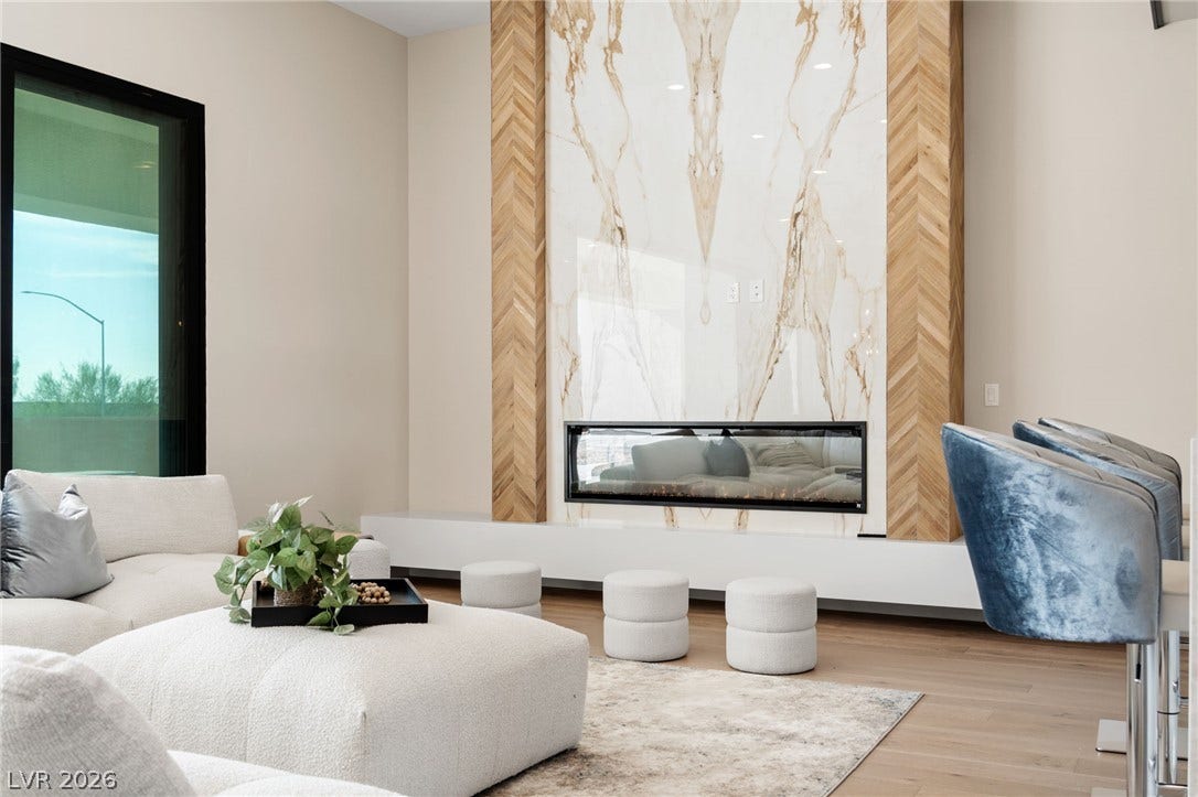 A striking floor-to-ceiling fireplace serves as the centerpiece of this modern living area.