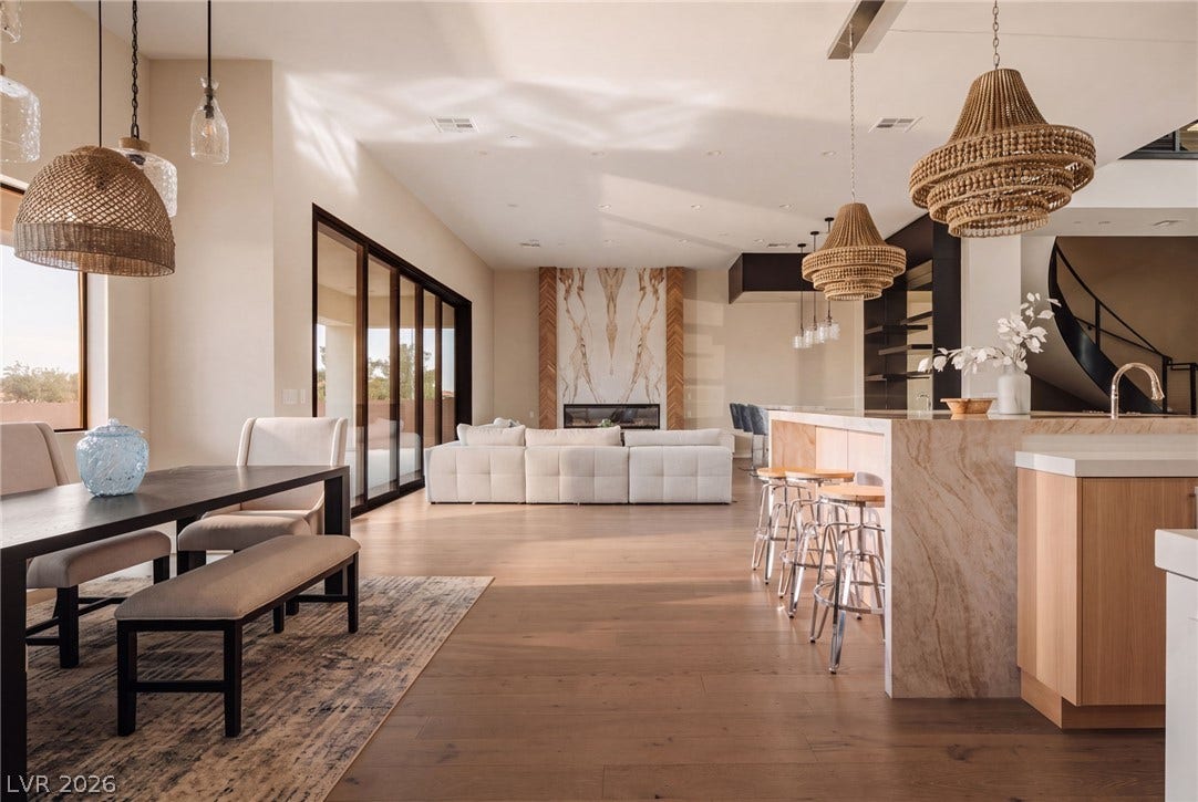 Rich hardwood floors sweep through an airy, open-concept main floor framed by massive sliding glass doors.
