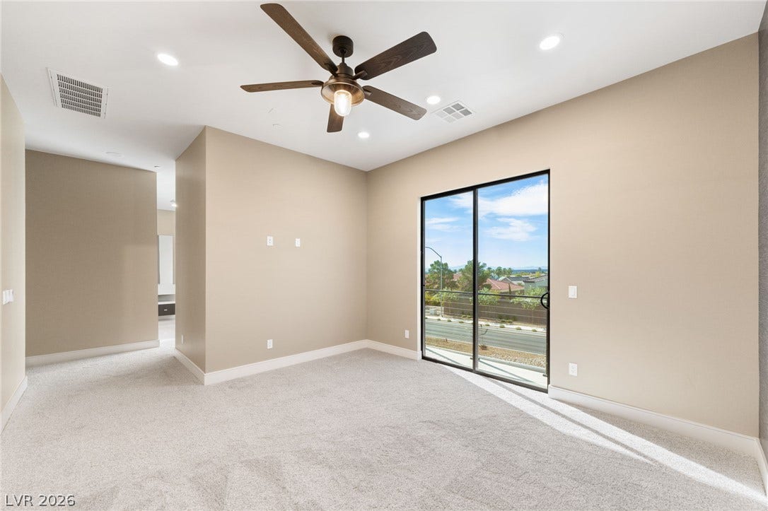 Sliding glass doors open to outdoor views from this carpeted bedroom suite.