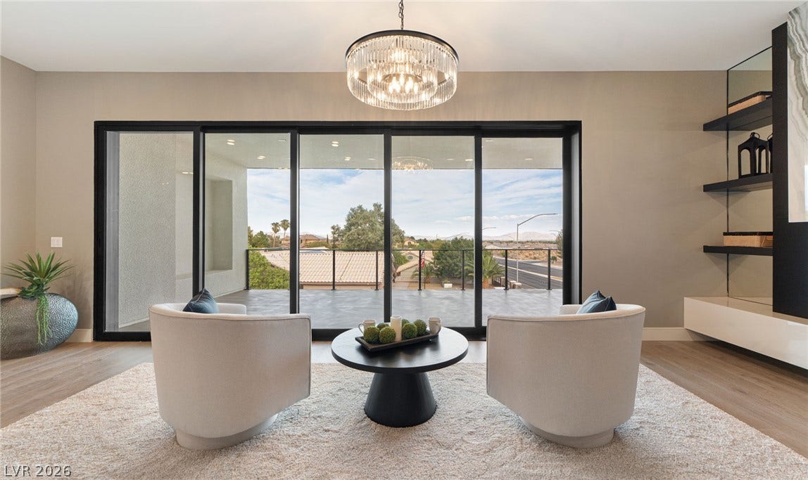 Massive sliding glass doors frame neighborhood views and open directly to a spacious balcony.