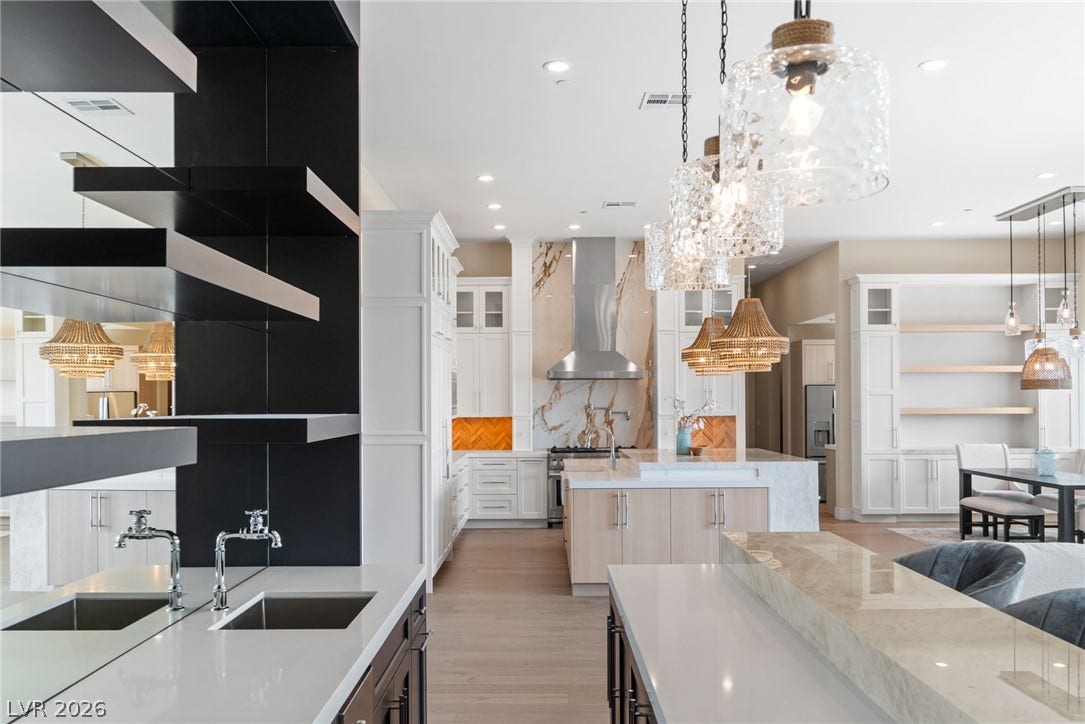 Recessed lighting and warm wood flooring enhance this open-concept culinary space.