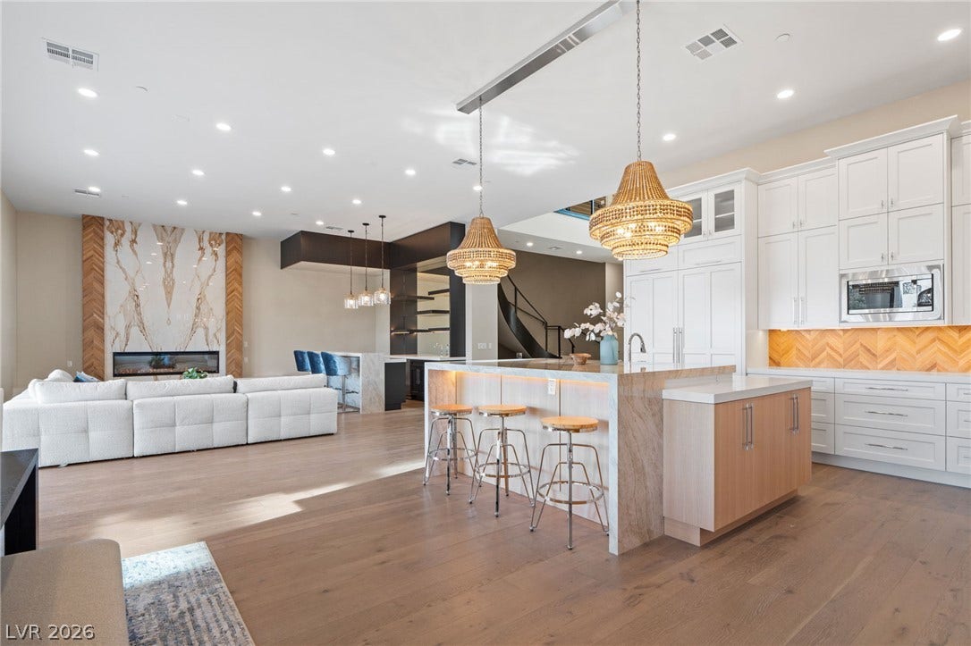 An open floorplan seamlessly connects the culinary space to the living area with hardwood floors.