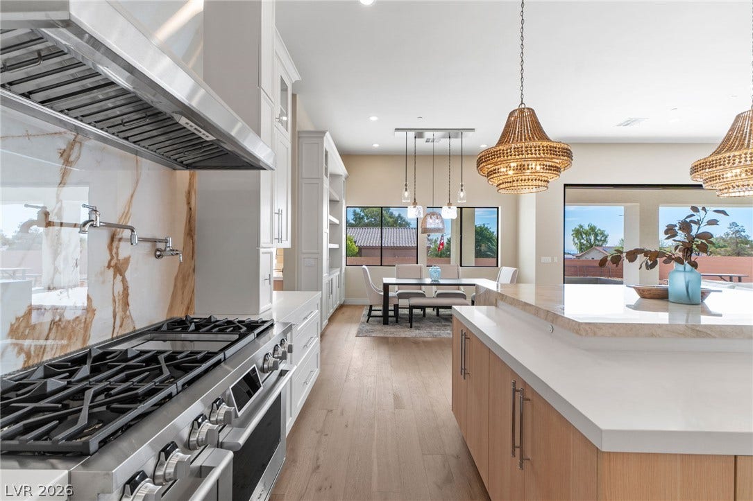 An open floor plan connects the gourmet kitchen to a light-filled dining space.