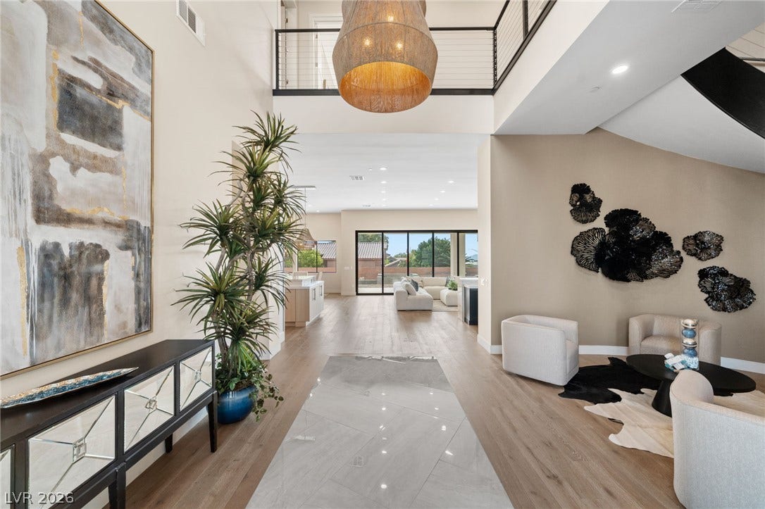 Soaring ceilings and elegant hard flooring define this grand entry area leading to the living spaces.