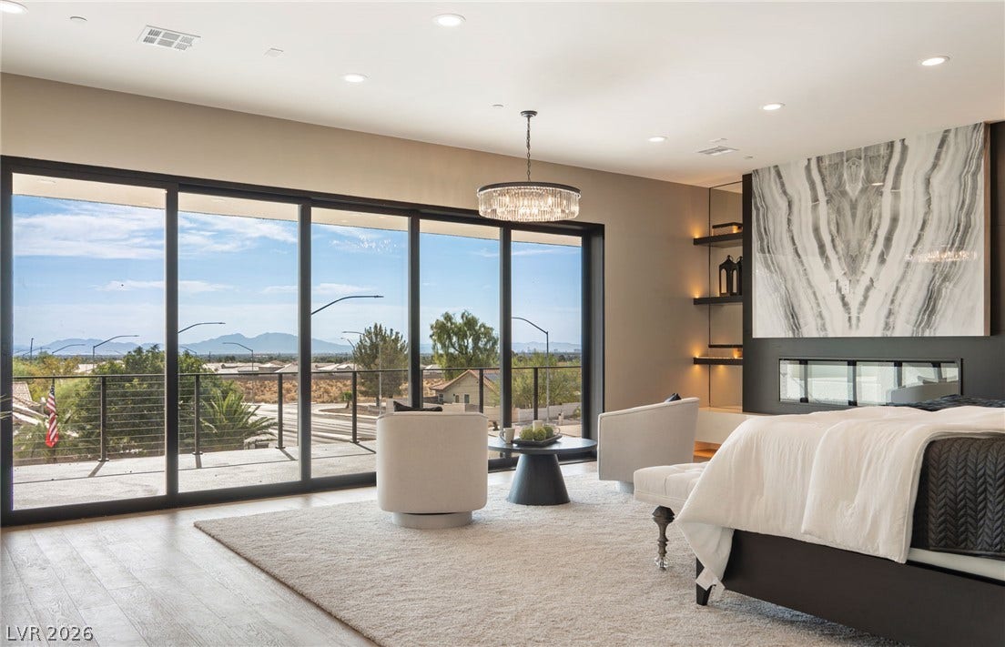 Massive sliding glass doors open to a private balcony overlooking scenic mountain views.