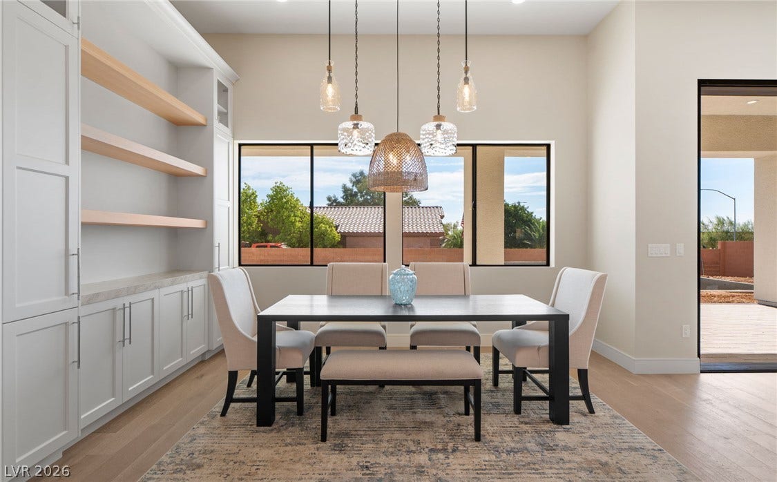 Elegant hardwood flooring anchors a dining area complete with custom built-ins and large window views.