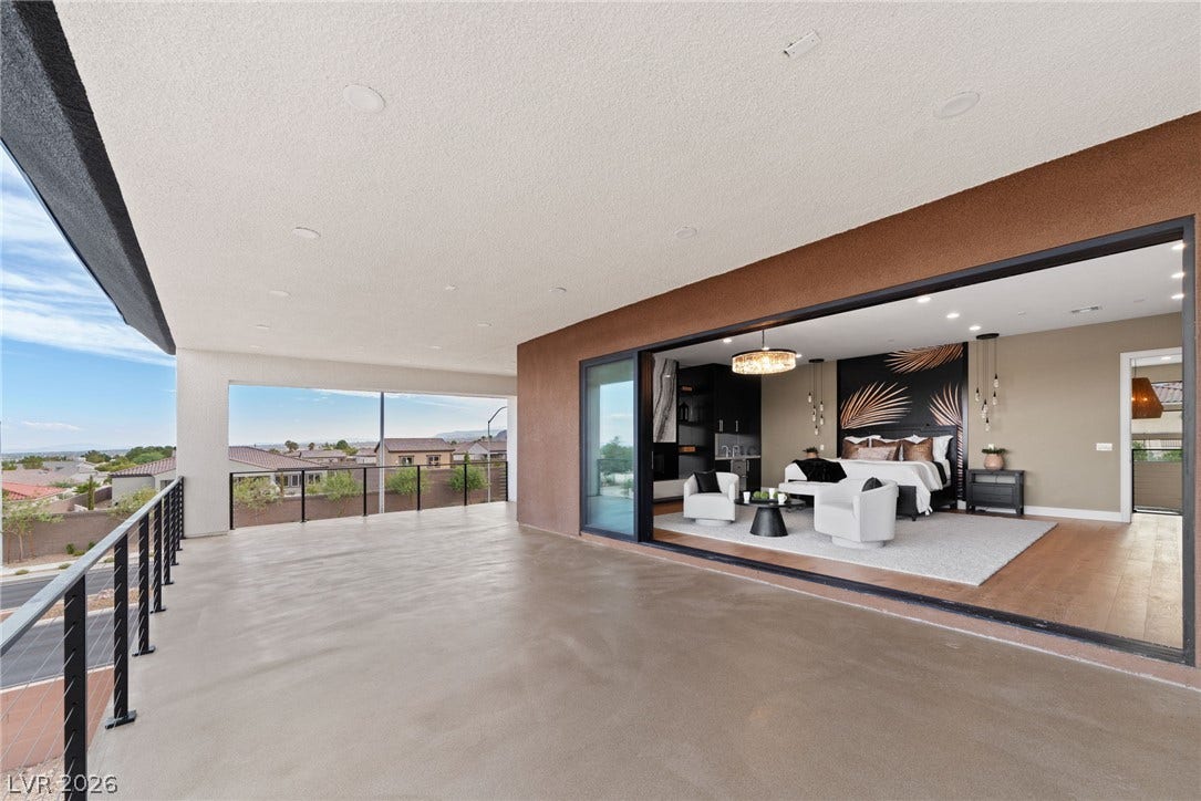 A spacious covered balcony provides sweeping neighborhood views through seamless sliding glass doors.
