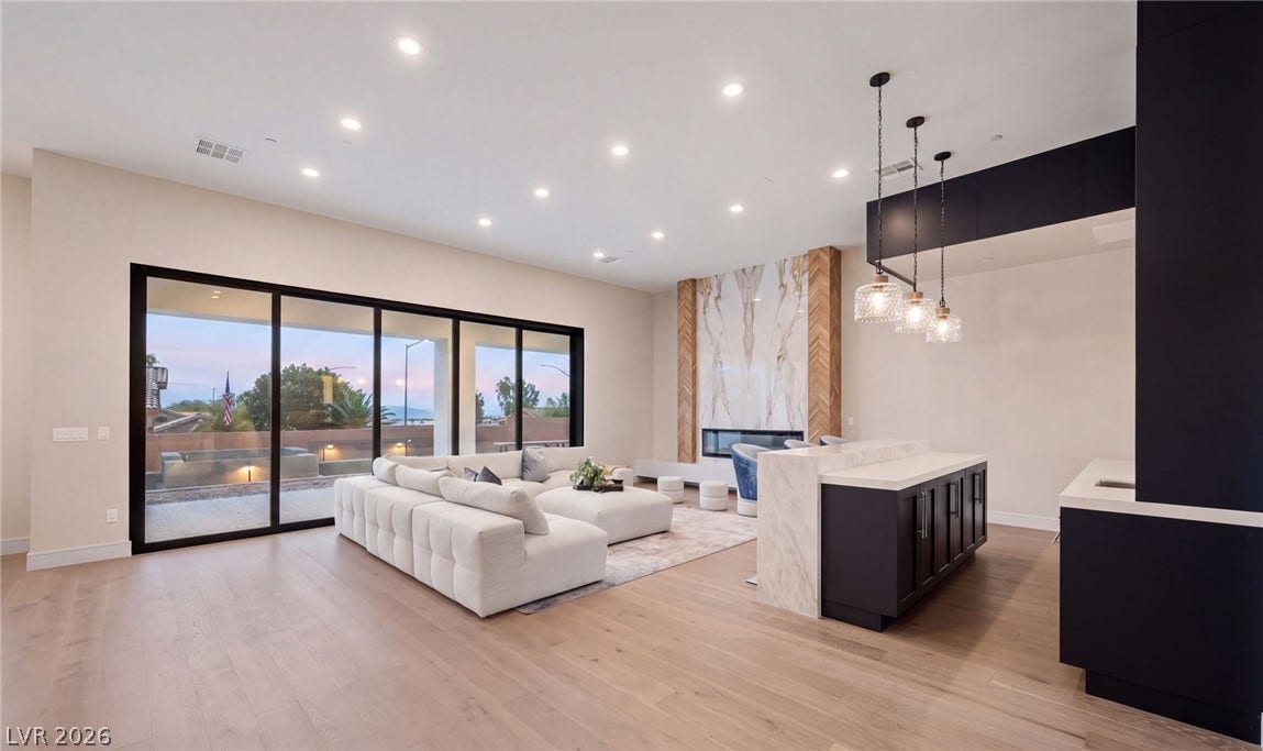 An open floorplan design seamlessly connects the modern kitchen space to the bright living room.