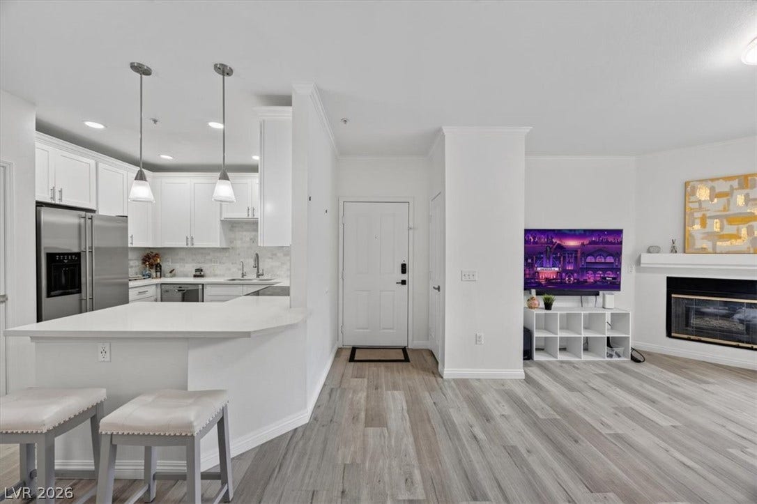 2900 Sunridge Heights Parkway, #1022, Henderson, NV 89052 Hardwood floors and an open-concept design connect the modern kitchen and living space.