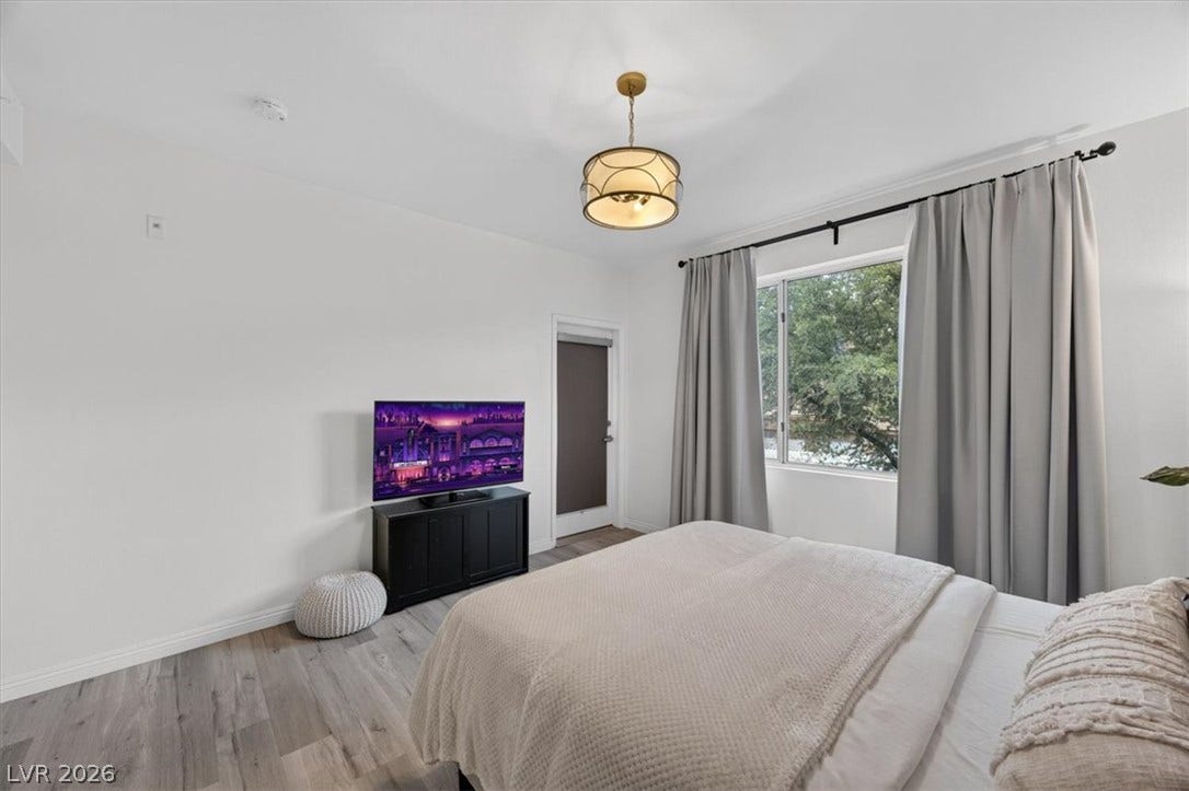 2900 Sunridge Heights Parkway, #1022, Henderson, NV 89052 Smooth wood-look flooring and a large picture window create a serene atmosphere in this bedroom.