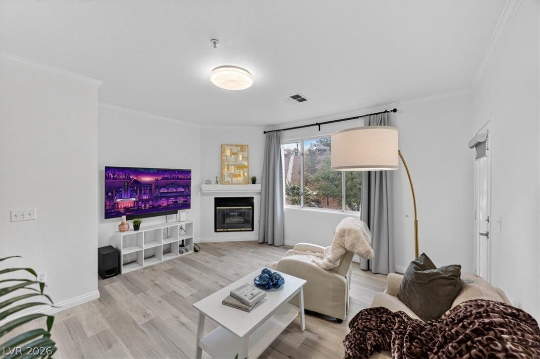 2900 Sunridge Heights Parkway, #1022, Henderson, NV 89052 Crisp white walls and clean-lined moulding frame a comfortable living space with wood-style flooring.