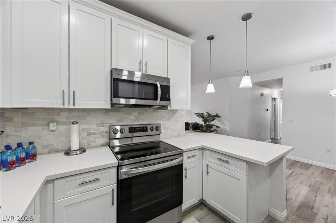 2900 Sunridge Heights Parkway, #1022, Henderson, NV 89052 Crisp white cabinetry paired with sleek solid surface countertops frames this contemporary culinary workspace.