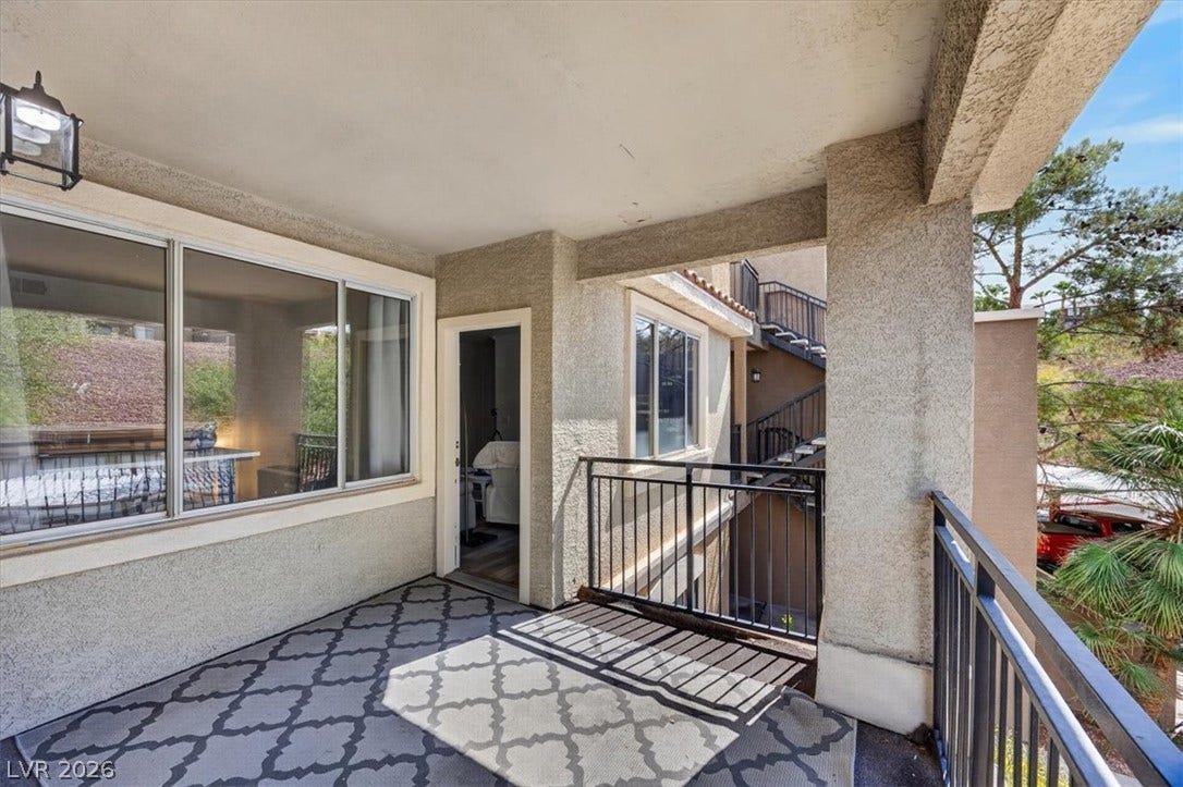 2900 Sunridge Heights Parkway, #1022, Henderson, NV 89052 Covered concrete balcony framed by stucco columns and metal railings overlooks the surrounding neighborhood.