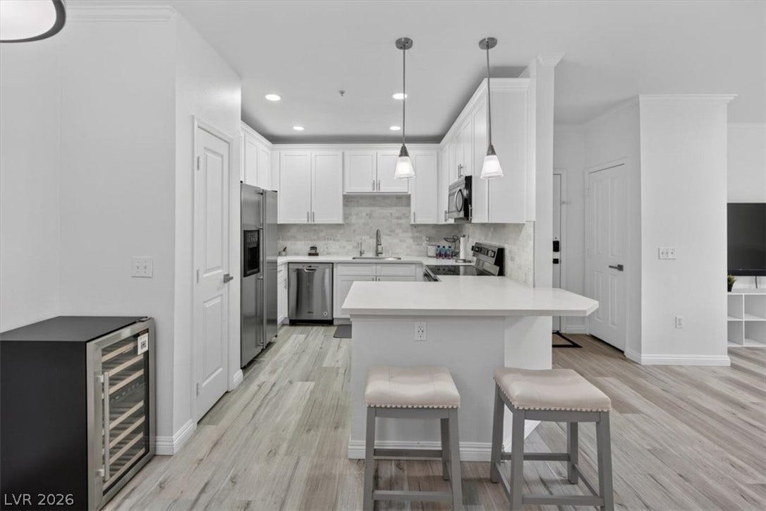 2900 Sunridge Heights Parkway, #1022, Henderson, NV 89052 An open floorplan connects the modern kitchen and breakfast bar to surrounding living spaces.