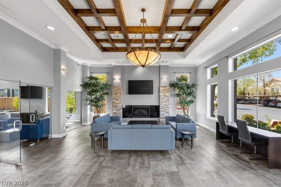 2900 Sunridge Heights Parkway, #1022, Henderson, NV 89052 An elegant coffered ceiling and stone fireplace anchor this welcoming open-plan clubhouse lounge.