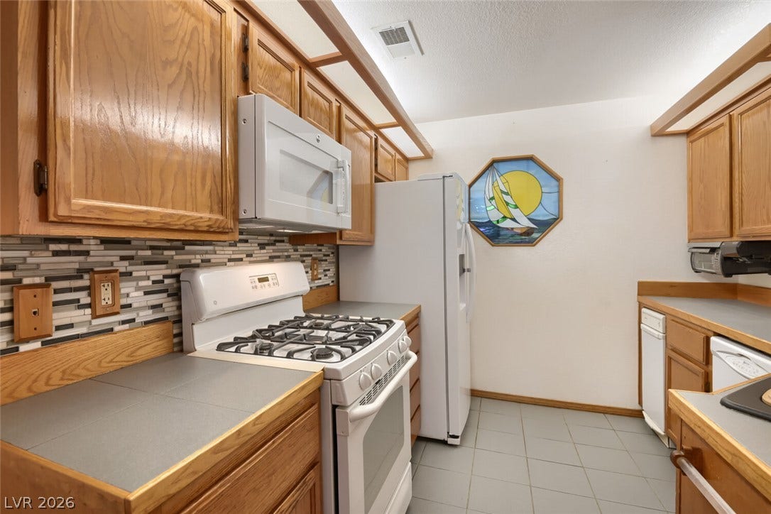 749 Tenderfoot Circle, Henderson, NV 89014 Oak cabinetry and tiled floors frame this functional workspace.