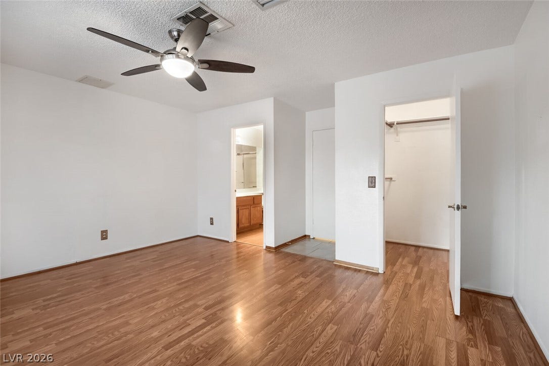 749 Tenderfoot Circle, Henderson, NV 89014 Polished wood floors and clean white walls define this airy primary suite with ensuite access.