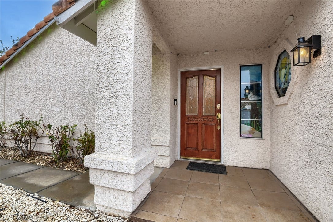 749 Tenderfoot Circle, Henderson, NV 89014 An inviting tiled entryway features a classic wood door and textured stucco finishes.