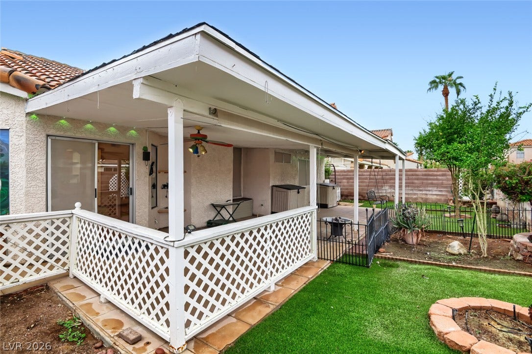 749 Tenderfoot Circle, Henderson, NV 89014 An inviting covered patio steps down to a landscaped grassy yard with a stone fire pit.