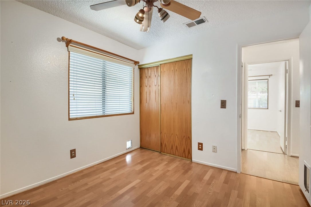 749 Tenderfoot Circle, Henderson, NV 89014 Warm wood flooring and built-in closet storage define this serene bedroom space.