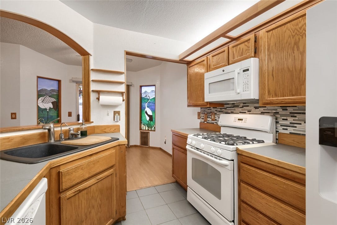 749 Tenderfoot Circle, Henderson, NV 89014 Oak cabinetry and a tile floor define this classic, functional kitchen workspace.