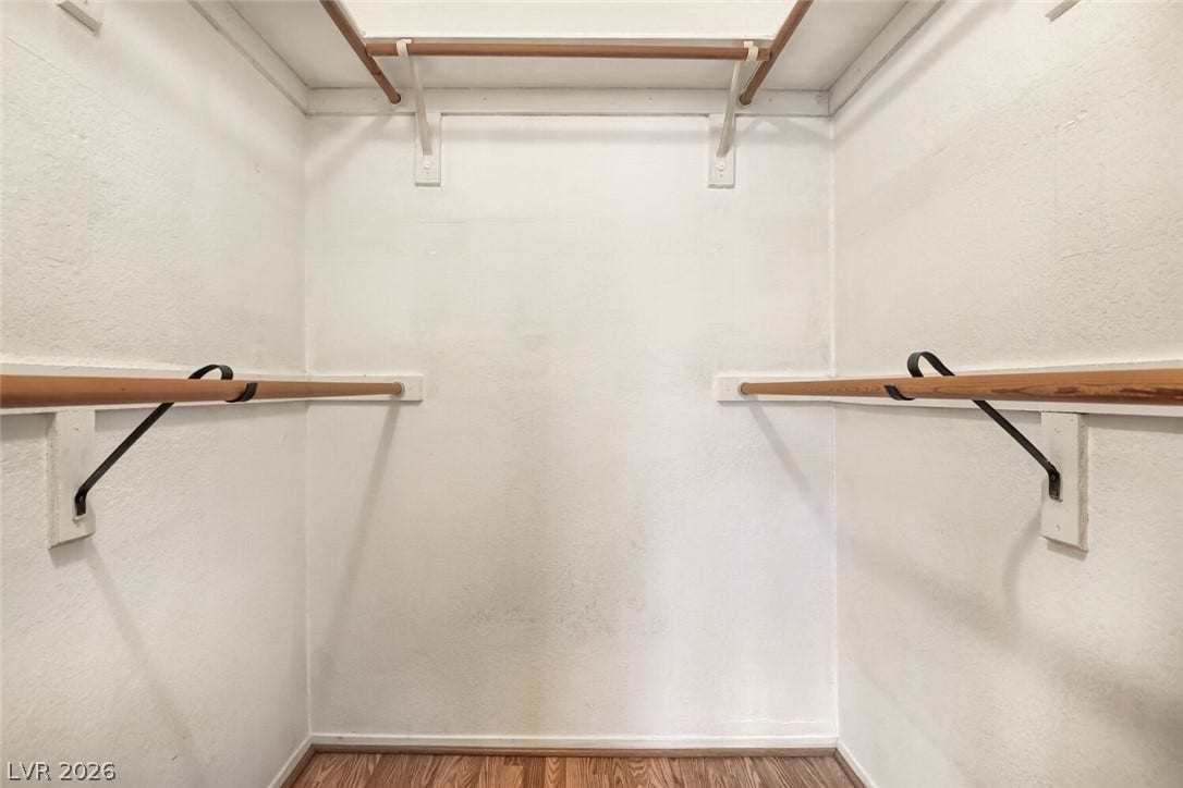 749 Tenderfoot Circle, Henderson, NV 89014 Ample hanging rods and wood flooring maximize organization in this functional walk-in closet.