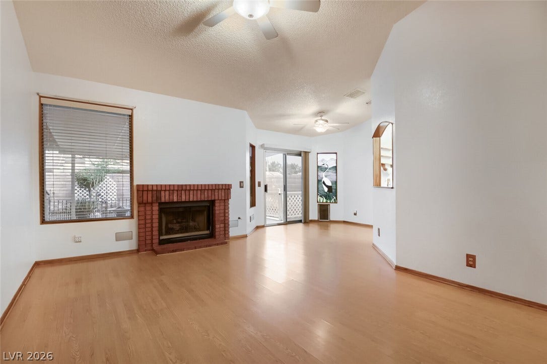 749 Tenderfoot Circle, Henderson, NV 89014 Warm wood flooring and a classic brick fireplace anchor this welcoming open living space.
